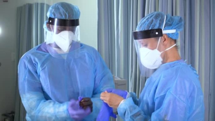 两名医护人员戴上PPE，戴上手术手套