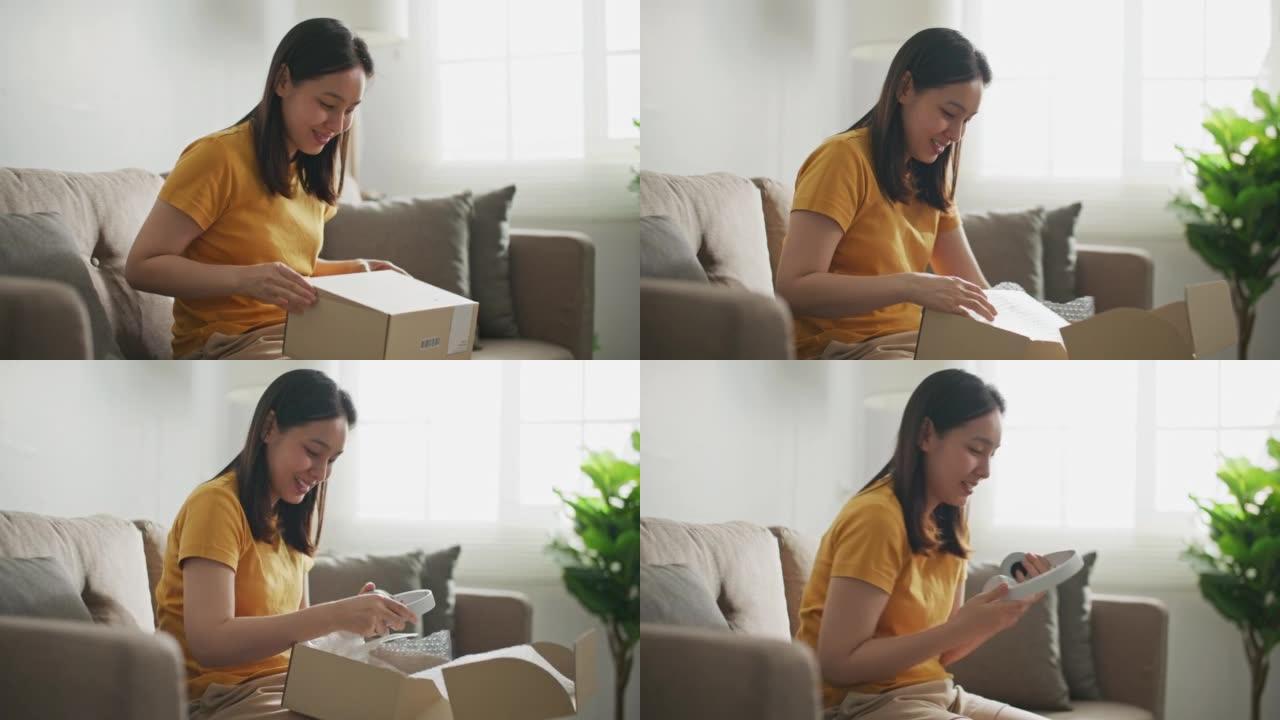 亚洲女性顾客在家打开快递包裹