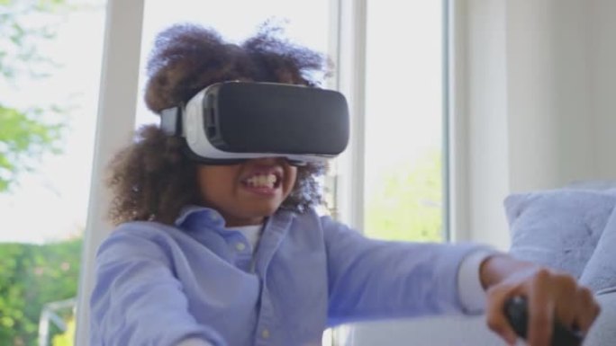 男孩坐在家里的地板上戴着VR耳机玩驾驶电脑游戏-慢动作拍摄