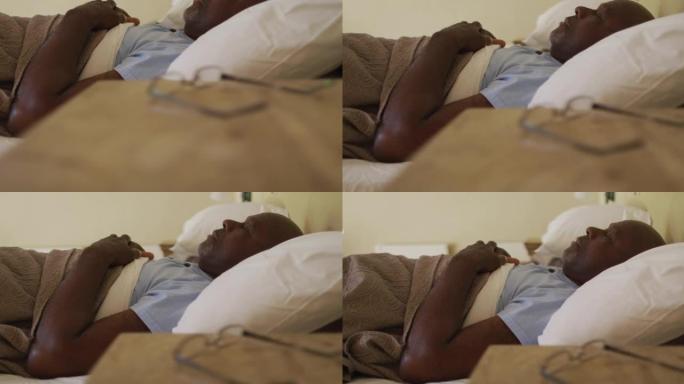 疲惫的非洲裔美国老人躺在床上睡着了