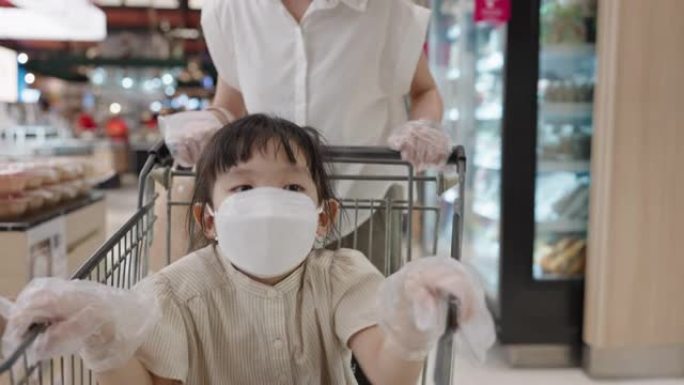 开朗的女儿戴口罩逛超市快乐亚洲家庭新常态生活方式