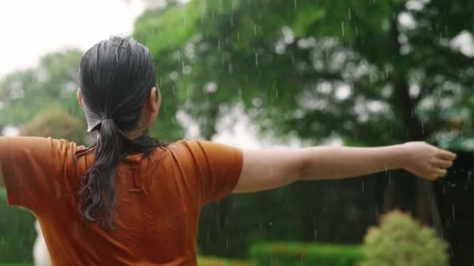 快乐的女人在夏天的雨中旋转