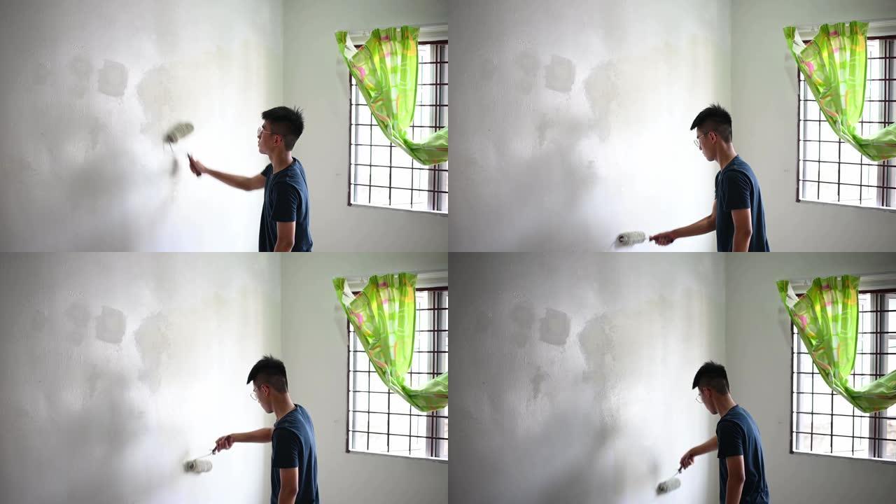 一个亚洲中国十几岁的男孩在日落时画他的卧室，公寓装修