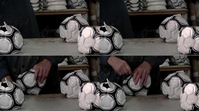 在一家足球工厂的生产线上，工人的手和放气的足球。特写。