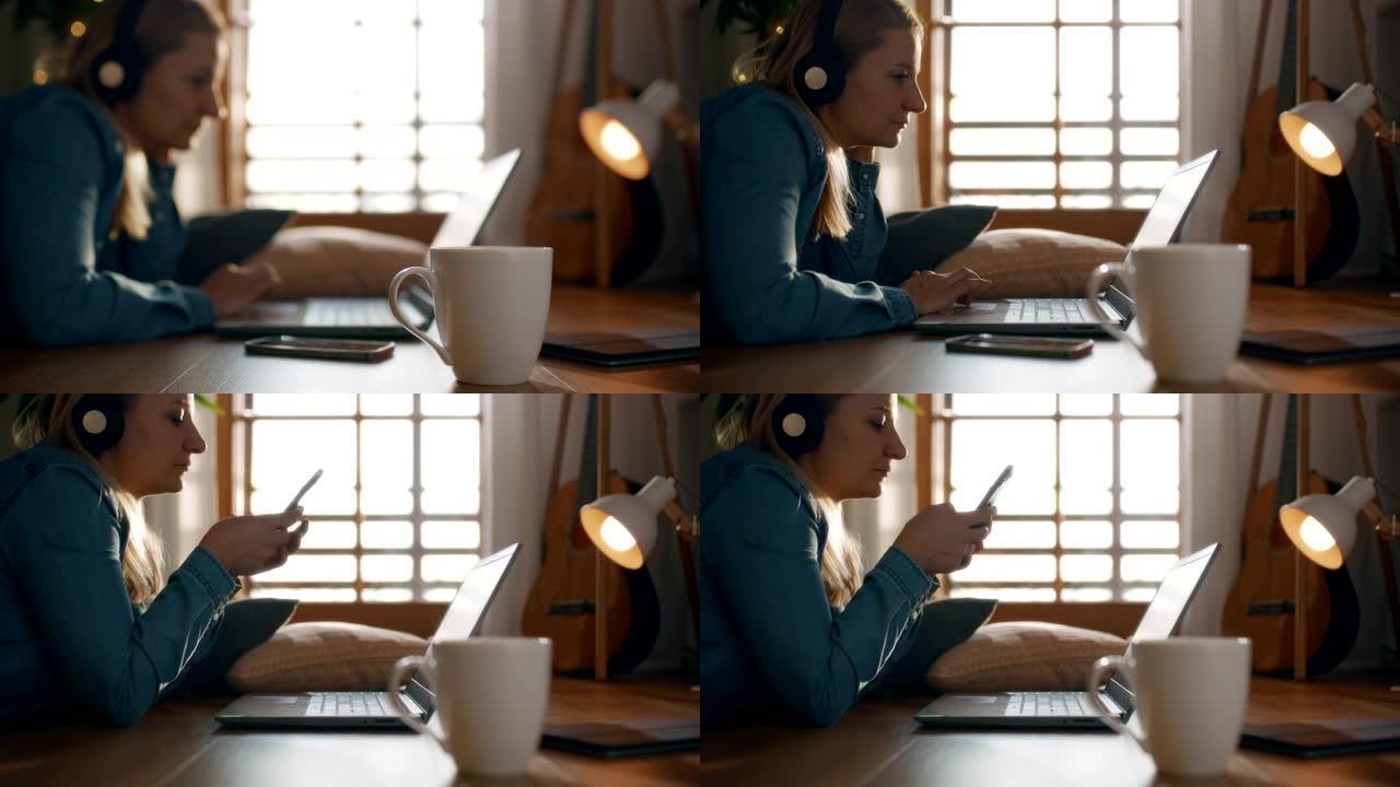 女士在地板上使用笔记本电脑和智能手机时听耳机上的音乐