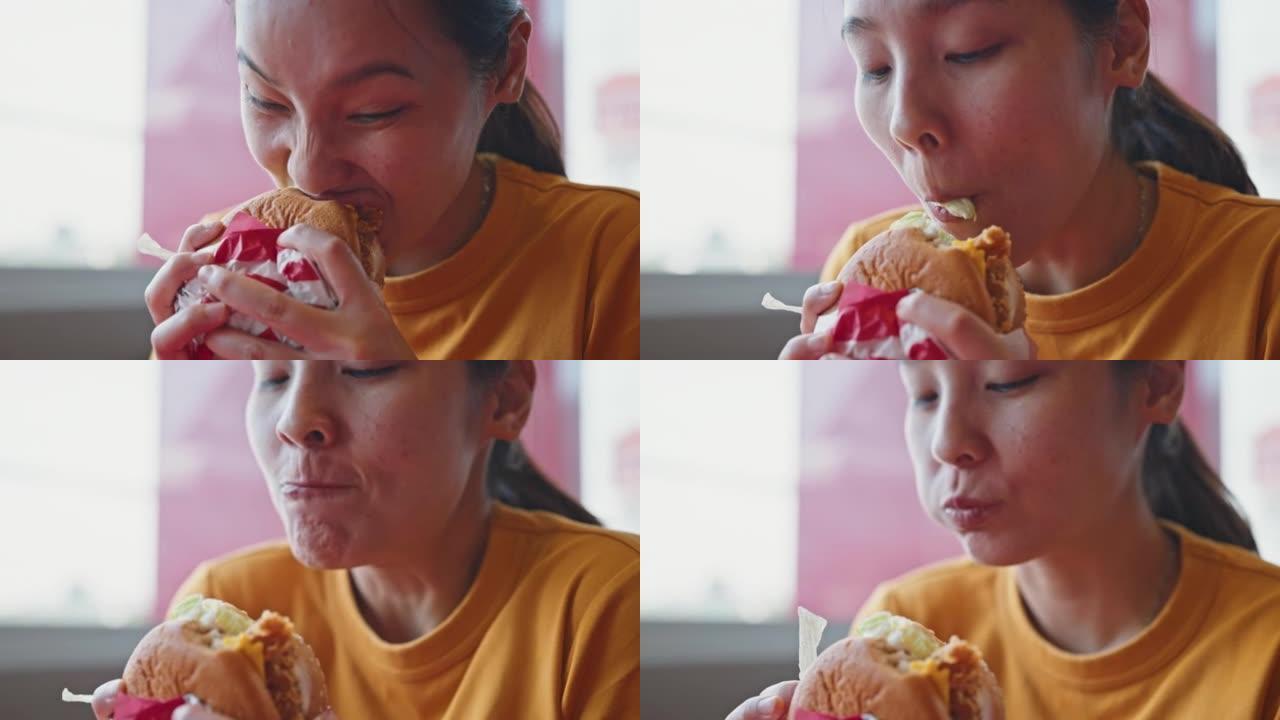 吃美味快餐汉堡的亚洲女人