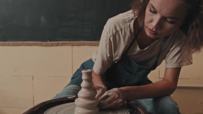在陶轮上制作古怪花瓶的女人