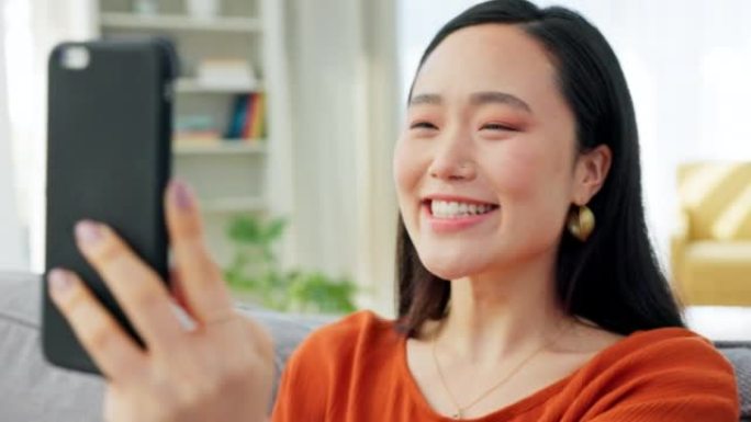 交流，电话和亚洲妇女在家里进行视频通话，交谈和交谈。技术、连接和快乐的韩国女孩在沙发上打电话、说话和