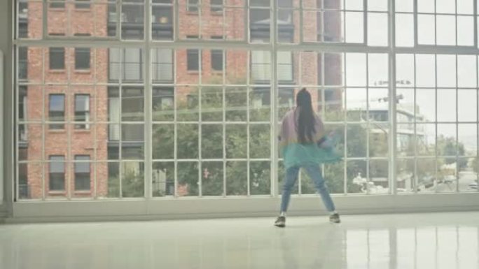 舞者，嘻哈和有影响力的女孩在一个有窗户和城市景观的舞蹈工作室里跳舞和练习动作时玩得很开心。年轻的精力