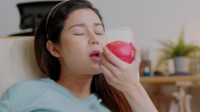 快乐孕妇在家吃新鲜的红苹果。