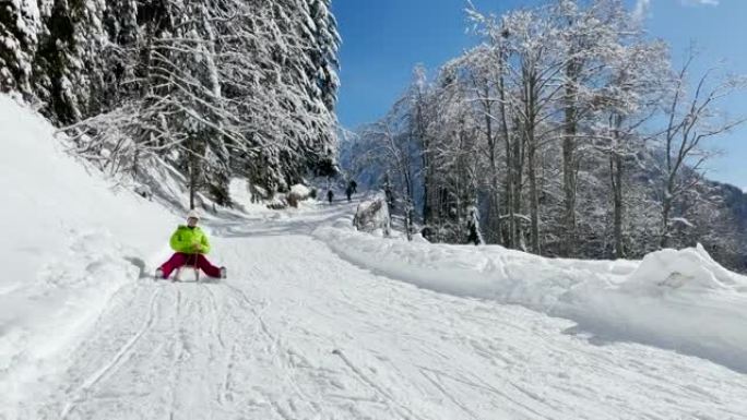 开朗的年轻白人妇女在阳光明媚的阿尔卑斯山滑下整洁的山坡。