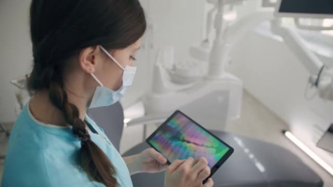 MS Real女牙医在数字平板电脑上看人牙x射线