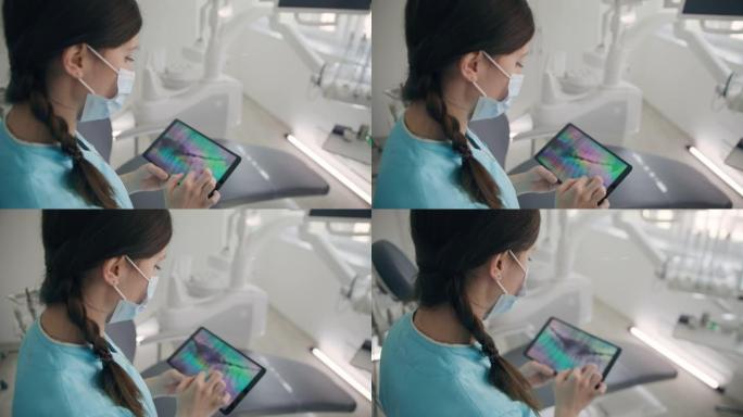 MS Real女牙医在数字平板电脑上看人牙x射线