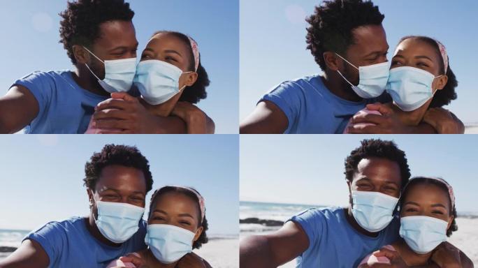 戴着口罩的非洲裔美国夫妇在海滩上看着相机的肖像