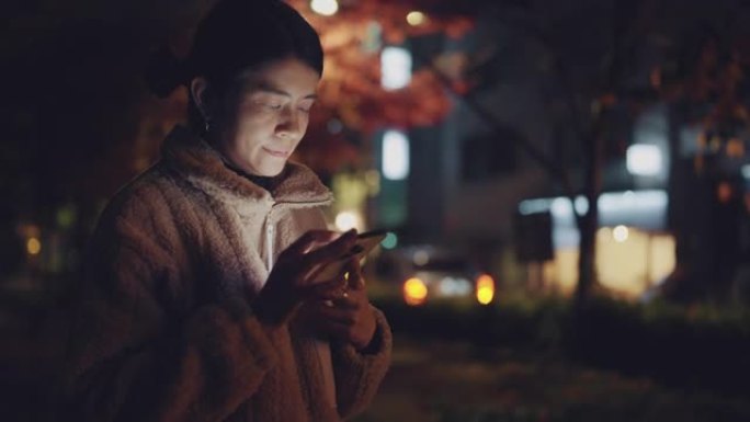 在韩国使用智能手机的亚洲女性快乐微笑。
