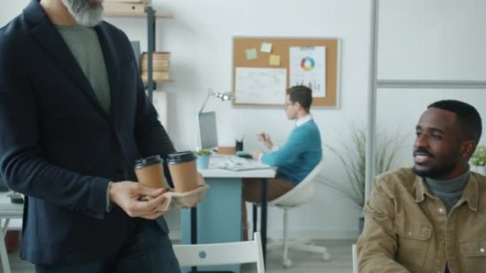 成熟的商人带咖啡去同事聊天讨论办公室工作