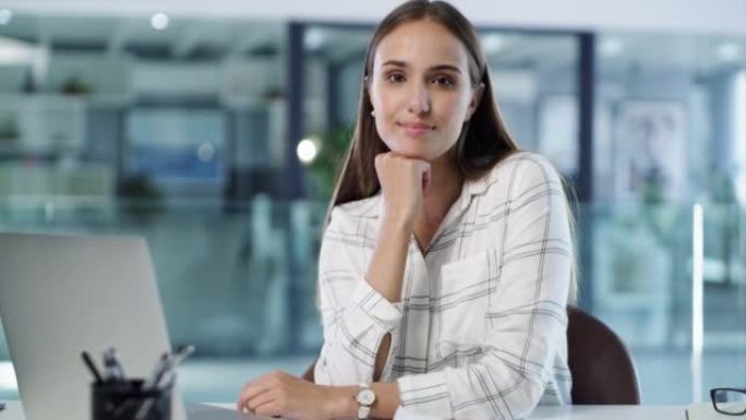 一位女商人使用笔记本电脑并在办公室向客户输入电子邮件。微笑的企业专业人士独自坐着的肖像，使用技术搜索