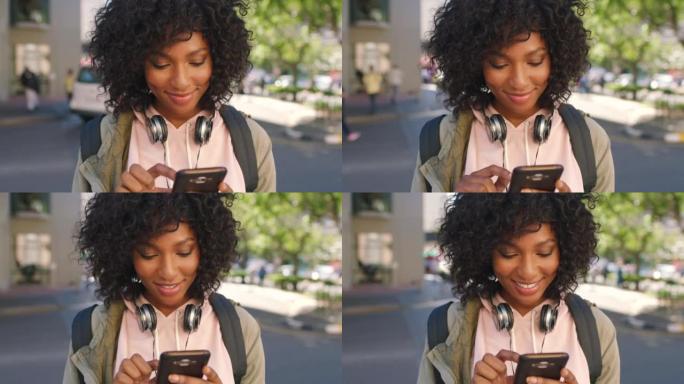 一位年轻时尚的黑人女学生在城市户外使用手机阅读社交媒体新闻。一个快乐的非洲女人站在校园里用手机浏览互