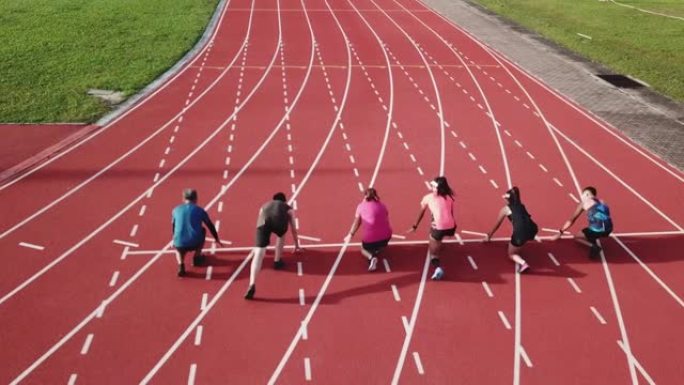 多样化运动直接高于无人机的观点亚洲中国运动员排队在跑道上冲刺，并在田径场上跑向终点线