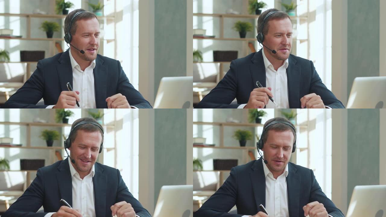 自信的商人在网上办公室谈论视频会议。微笑的经理在笔记本电脑上与客户通话。英俊的成人专业推销员说话。穿