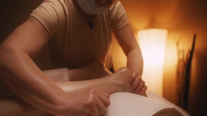 SLO MO专业按摩治疗师为一位年轻女性的腿进行油按摩