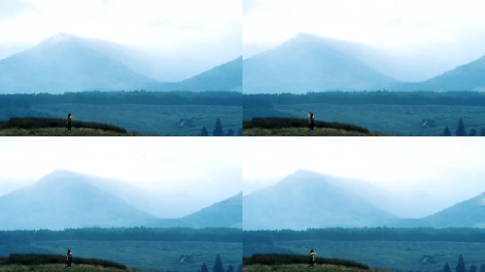 4k视频片段，一名妇女在远足时拍摄了一座山的照片