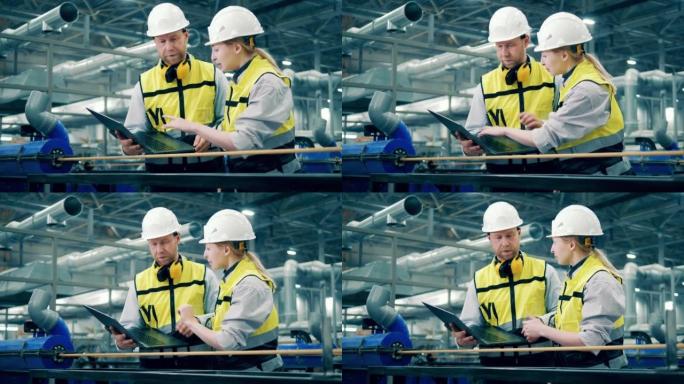 两名带笔记本电脑的工厂工人正在观察玻璃纤维物品。