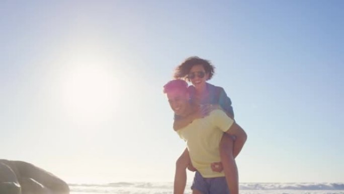 4k视频片段，一对年轻夫妇在海滩上结为纽带，互相背着