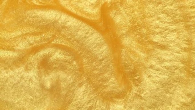 闪闪发光的金色液体涂料流动覆盖层。