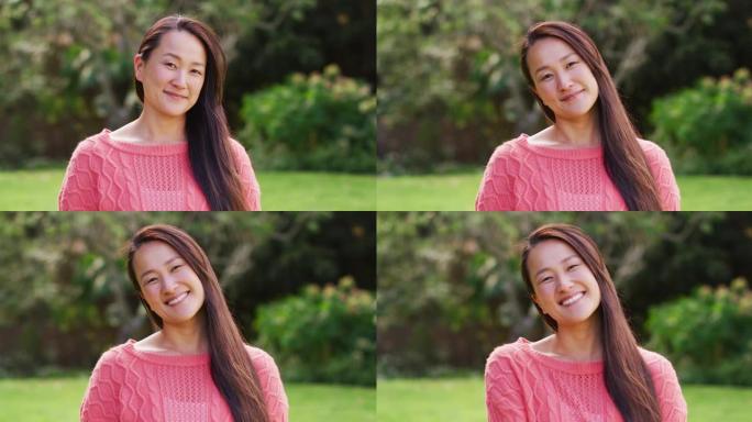 快乐的亚洲女人的肖像在花园里看着镜头微笑和大笑