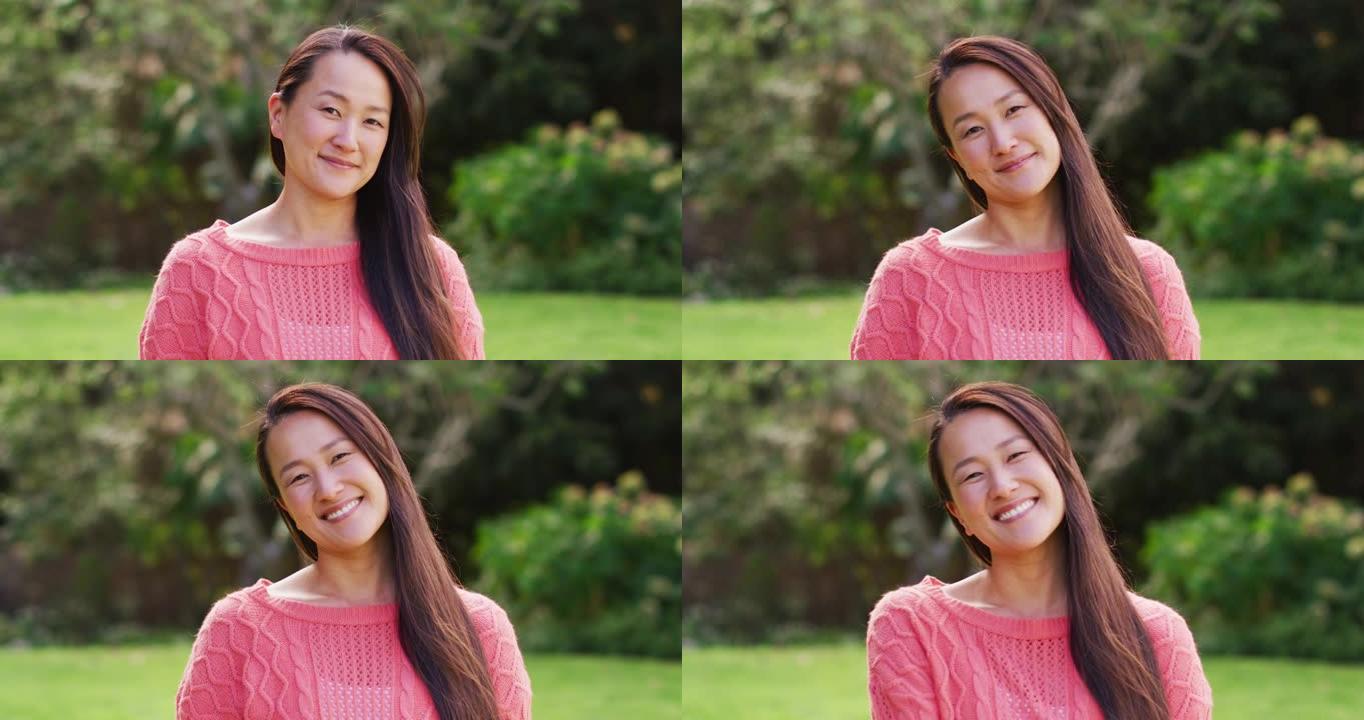 快乐的亚洲女人的肖像在花园里看着镜头微笑和大笑