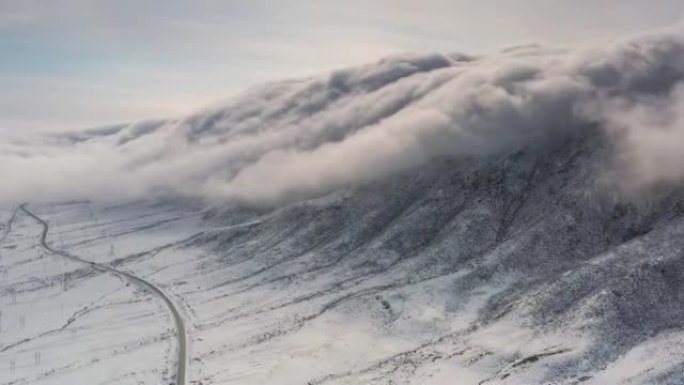 云层的瀑布从山顶倾泻而下，淹没了山谷的道路