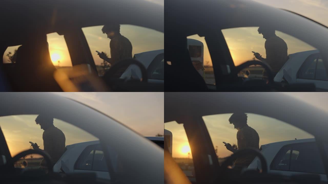 非洲男子在停车场靠在汽车上时使用手机