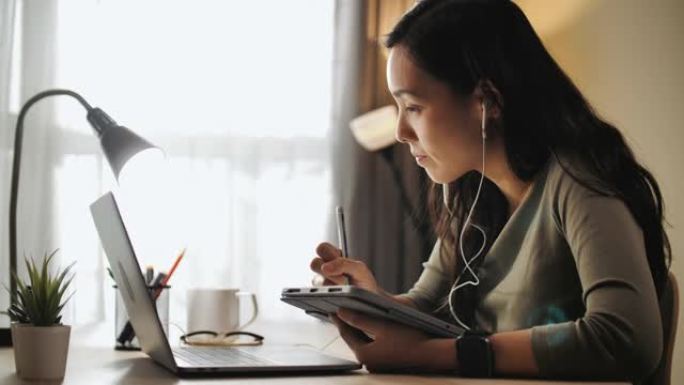 女人在家里的笔记本电脑上学习