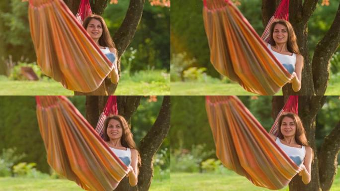 夏天，年轻女子躺在树下的吊床上，放松和做白日梦