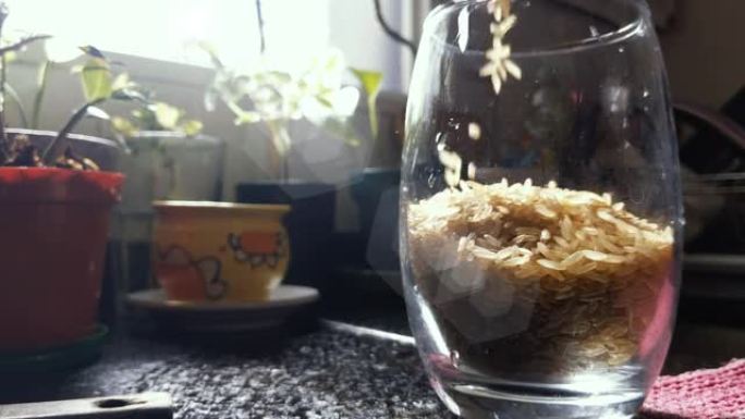 大米落在玻璃杯里的特写镜头。