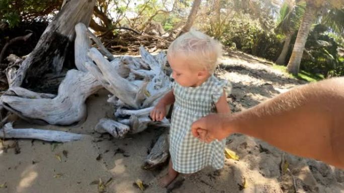 在阳光明媚的夏日，POV父亲与可爱的婴儿蹒跚学步的女儿在热带海滩上牵手