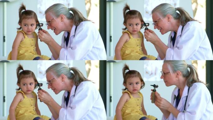 医生看着小女孩的耳朵