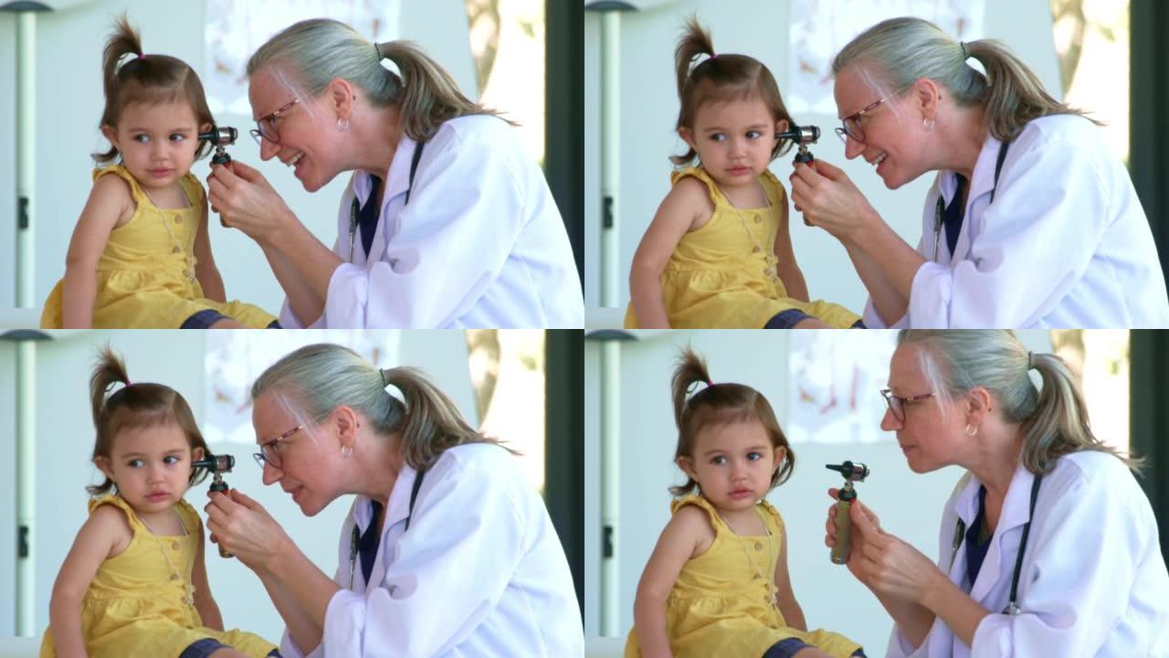 医生看着小女孩的耳朵