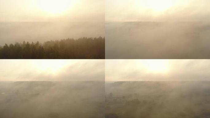 在阴天的夏日黎明，无人驾驶飞机缓缓飞过神秘的日出雾谷，树木和河流覆盖着浓雾。