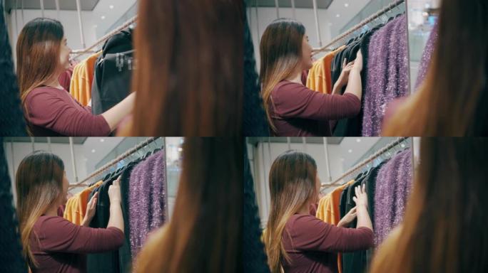女人在服装店的吊轨上选择衣服