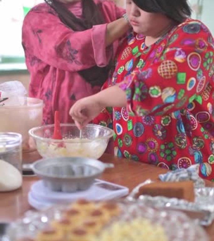 马来西亚母亲和她的唐氏综合症女儿在厨房里制作传统的马来甜点