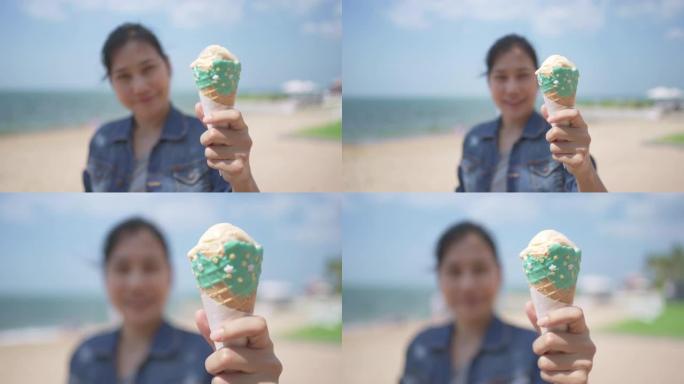 夏天在海滩上展示冰淇淋蛋卷的亚洲妇女