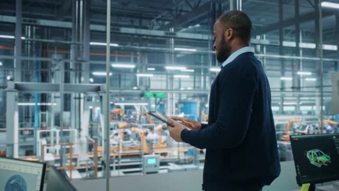 汽车厂办公室: 成功的黑人男性总工程师肖像在自动化机器人手臂装配线上使用平板电脑制造高科技电动汽车。