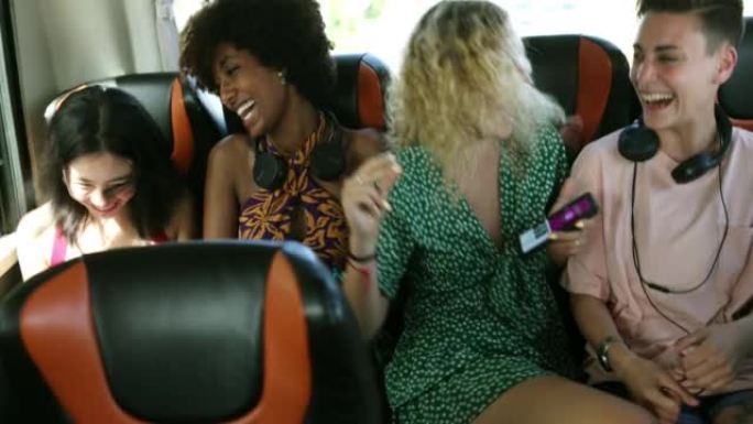 顽皮的年轻女性在公交车的后排听音乐