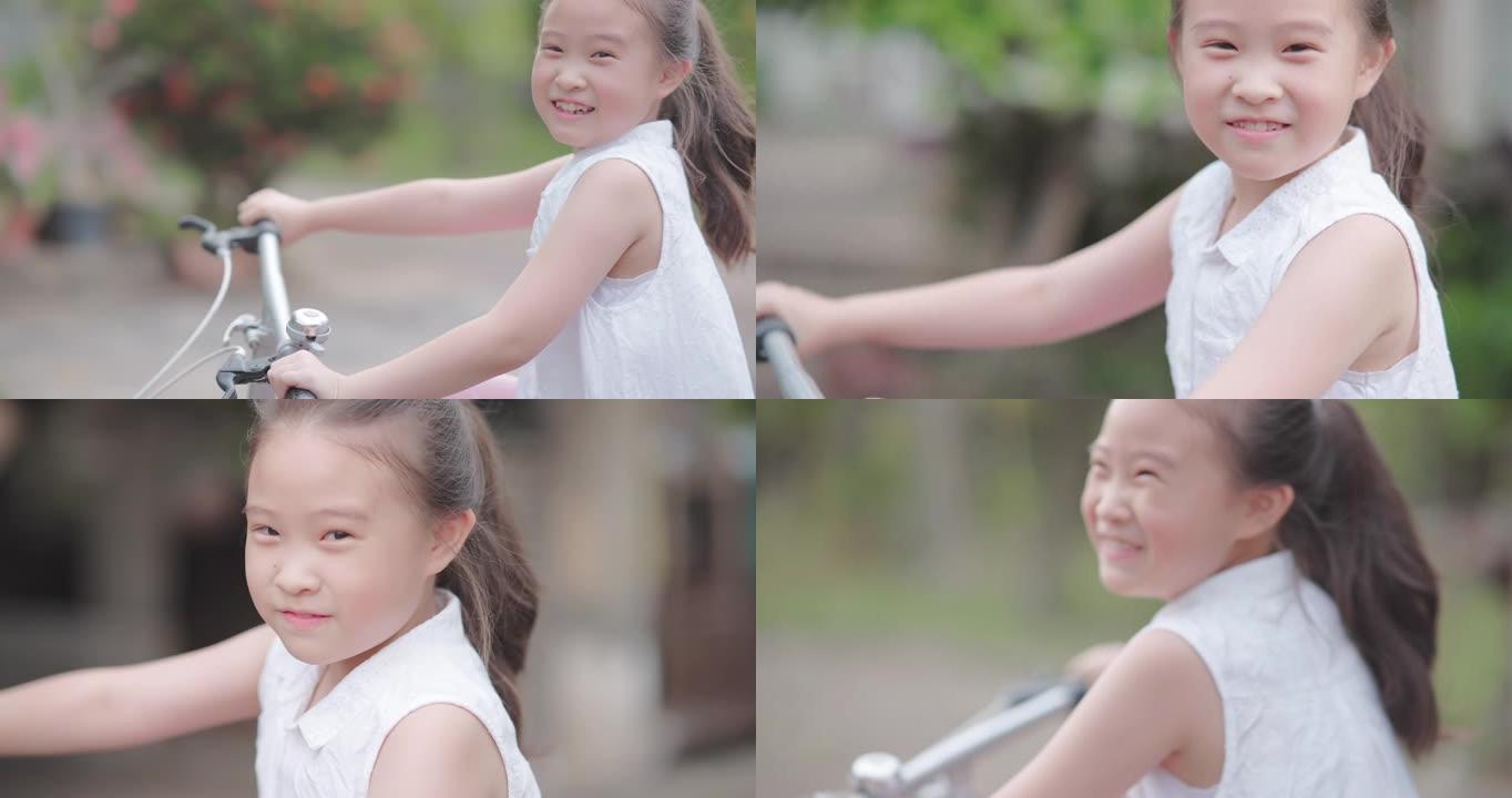 SLO MO可爱快乐亚洲小女孩骑红色自行车