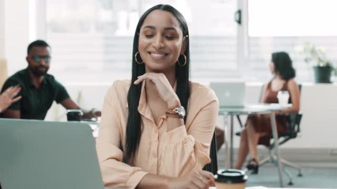 4k视频片段，一名年轻的女商人坐在办公室里使用技术，而她的同事在她身后工作