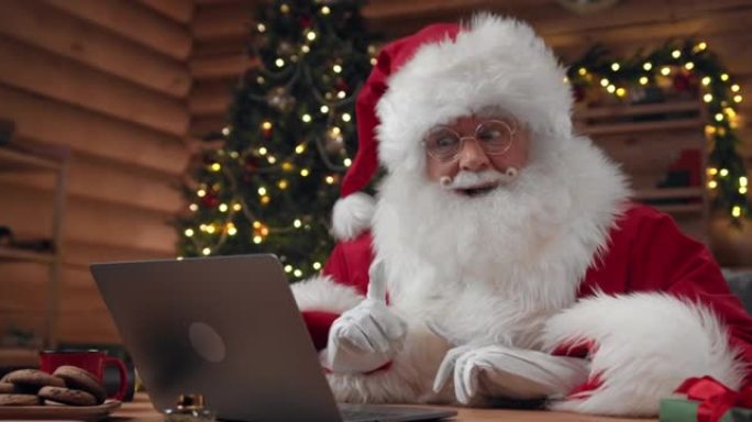 圣诞老人在笔记本电脑上进行视频聊天时对某人的话感到惊讶