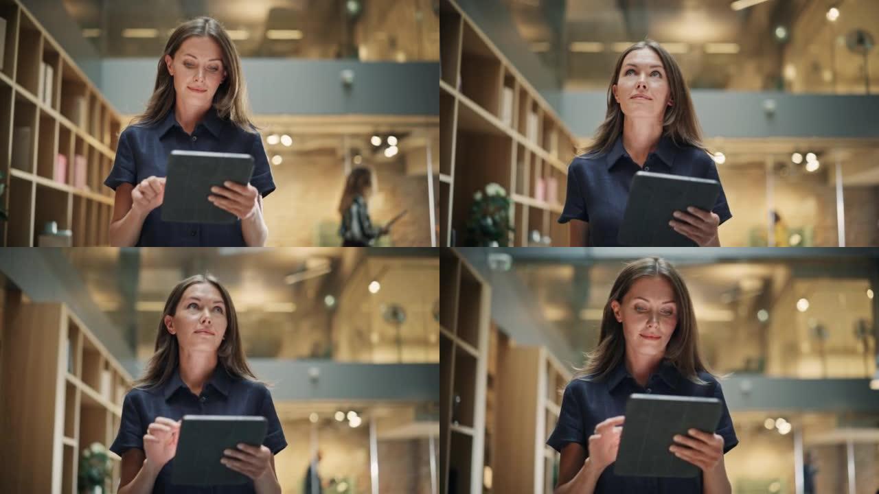 特写一位内容丰富的女首席执行官在她的平板电脑上做笔记。一个白人妇女穿过公司办公室大厅的肖像，微笑着，