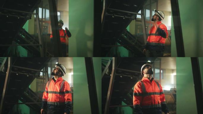 男工程师检查传送带下的机械